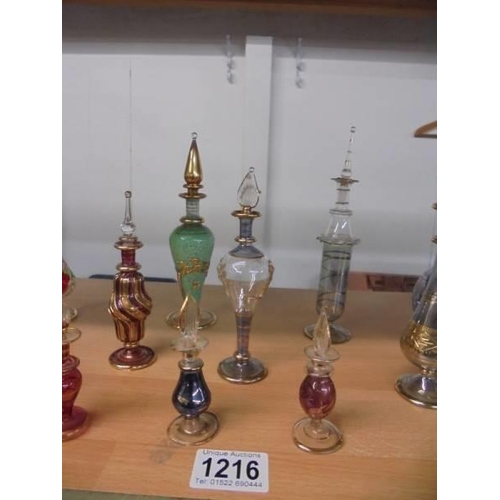 1216 - Fourteen coloured glass perfume bottles (one missing stopper).