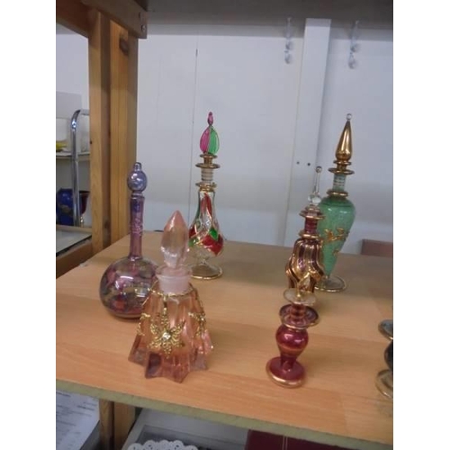 1216 - Fourteen coloured glass perfume bottles (one missing stopper).