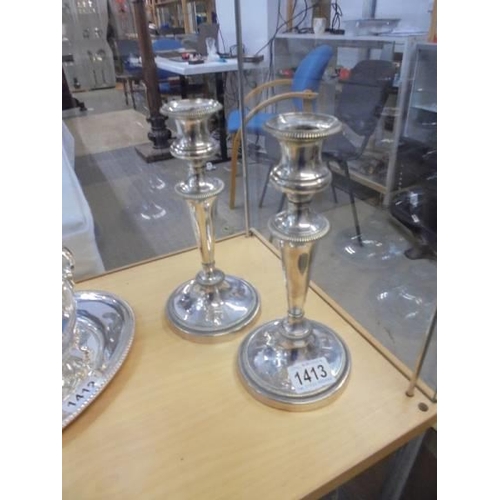 1413 - A pair of silver plate candlesticks.