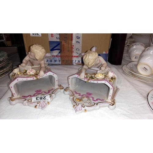 283 - A pair of continental bisque winged cherub wall pockets