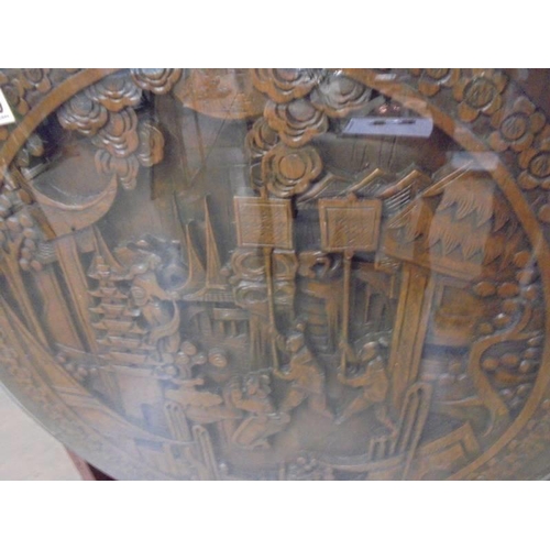 1470 - A heavily carved oriental tip top table with glass top. COLLECT ONLY.