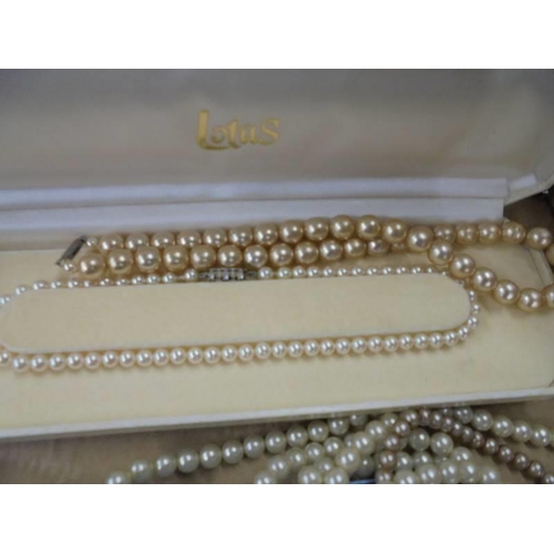 1236 - A cased string of Lotus pearls and four other pearl/faux pearl necklaces.