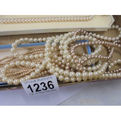 1236 - A cased string of Lotus pearls and four other pearl/faux pearl necklaces.