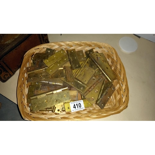 410 - A quantity of brass door hinges and an old tin