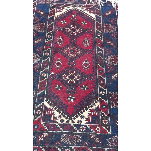 773 - A blue/red patterned rug, 76