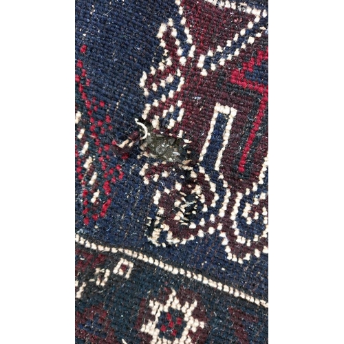 773 - A blue/red patterned rug, 76