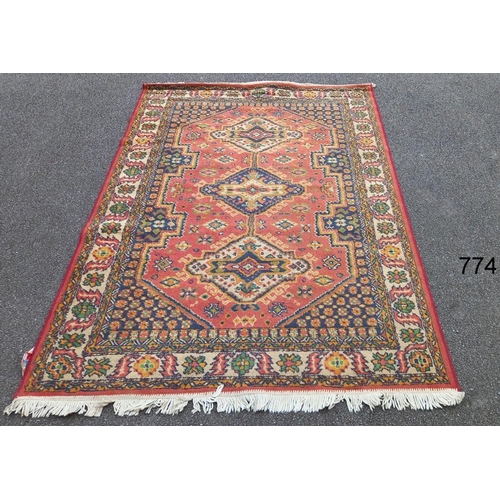 774 - A red patterned rug,  86