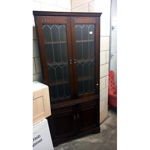 869 - A dark oak corner cupboard with leaded glass doors COLLECT ONLY