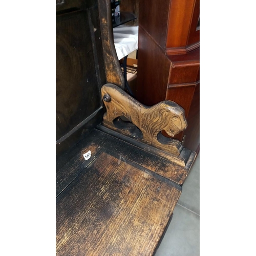 141 - An oak monks bench with carved lions arms COLLECT ONLY