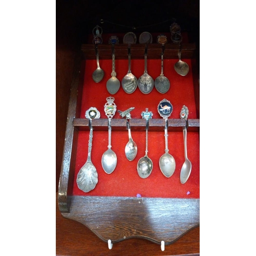 143 - A good selection of tourists collectors spoons etc on racks