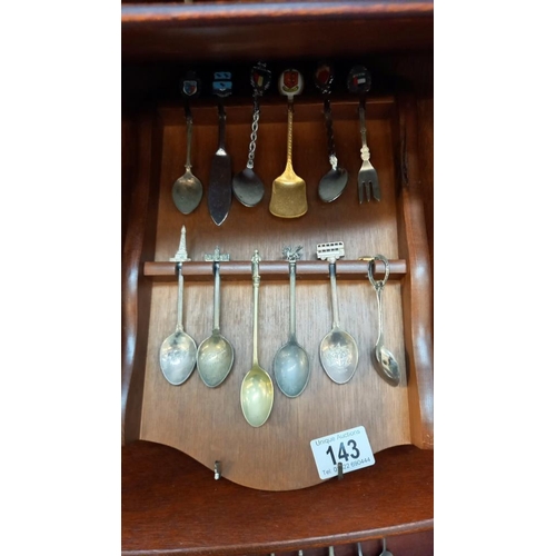 143 - A good selection of tourists collectors spoons etc on racks