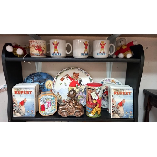 252 - A good selection of Rupert The Bear collectables including pin badges, tins, mugs & money boxes etc.... 