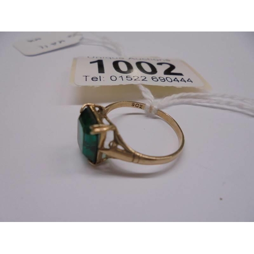 1002 - A yellow gold ring set green coloured stone, size M half, 1.8 grams.