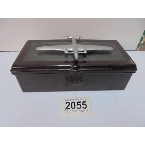 2055 - A vintage bakelite cigarette box with surmounted white metal aeroplane, 17 x 8.5 x 6 cm,