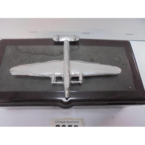 2055 - A vintage bakelite cigarette box with surmounted white metal aeroplane, 17 x 8.5 x 6 cm,