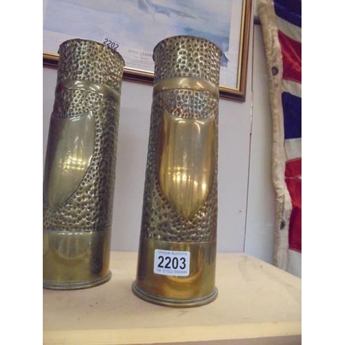 2203 - A pair of WW1 trench art decorated brass gun shells.