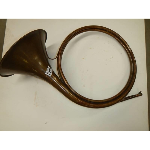 2303 - An unusual copper horn with multiple loops, approximate diameter 40cm, (missing mouthpiece).