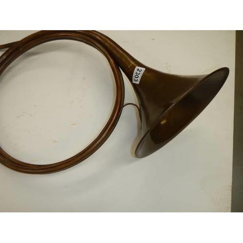 2303 - An unusual copper horn with multiple loops, approximate diameter 40cm, (missing mouthpiece).