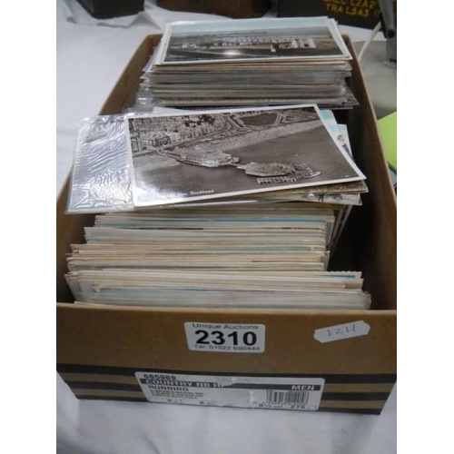 2310 - A box of vintage postcad, mostly seaside towns.