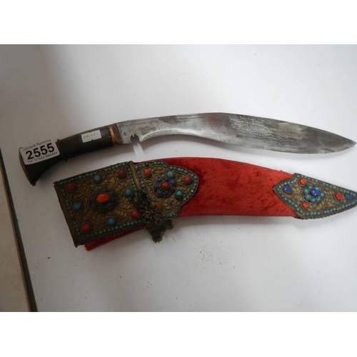 2555 - A vintage kukri with stone encrusted gilded red velvet scabbard.