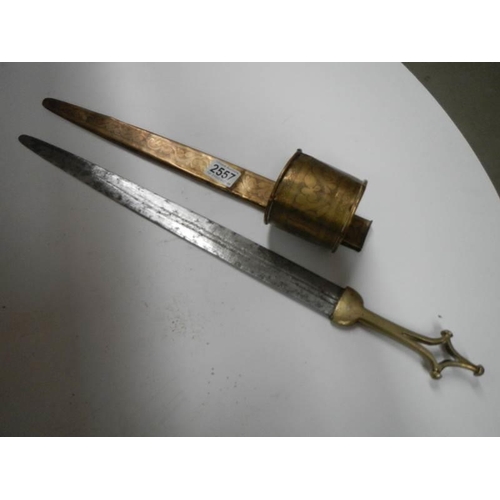 2557 - A North African assassins blace with brass handle and scabbard with bracelet, COLLECT ONLY.