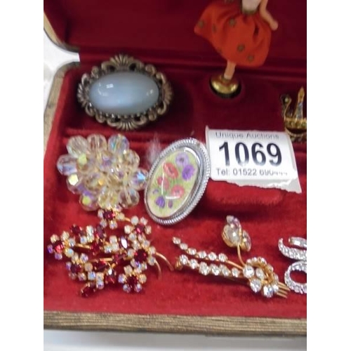 1069 - A good lot of vintage brooches in a jewellery box.