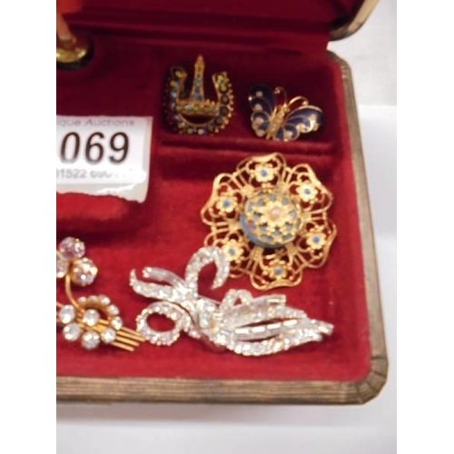 1069 - A good lot of vintage brooches in a jewellery box.