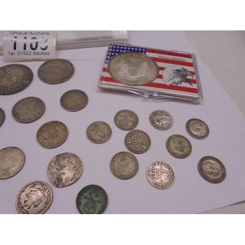 1103 - A collection of silver coins including American Eagle silver dollar.