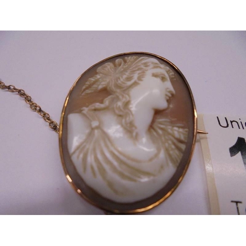 1125 - A shell cameo brooch of a female profile in a 9ct gold mount with safety chain.