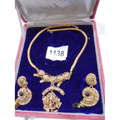 1138 - A cased ornate necklace with matching earrings.