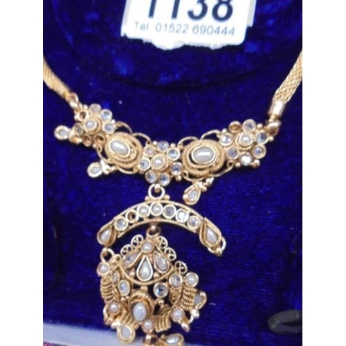 1138 - A cased ornate necklace with matching earrings.