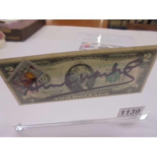 1139 - An Andy Warhol signed two dollar bill in perspex frame with certificate of authenticity.