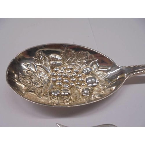 1179 - A silver plate fruit spoon, a pickle fork with silver handle and a spoon with a 1776 coin bowl.