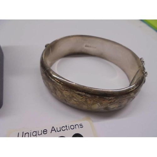 1189 - A silver bangle, silver chain and two silver rings, 47 grams.