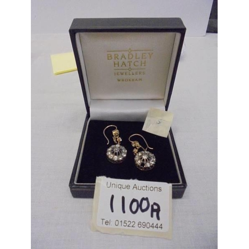 1100A - A pair of diamond earrings, (one stone needs refixing) total weight 5.95 grams.