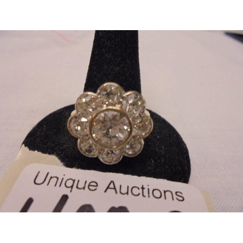 1100C - An 18ct round cluster head ring set with an early round brilliant cut diamond surrounded by 8 old cu... 