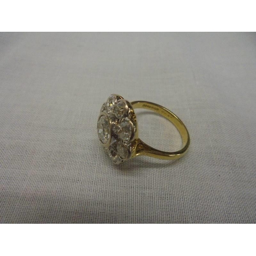 1100C - An 18ct round cluster head ring set with an early round brilliant cut diamond surrounded by 8 old cu... 