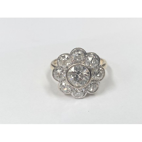 1100C - An 18ct round cluster head ring set with an early round brilliant cut diamond surrounded by 8 old cu... 