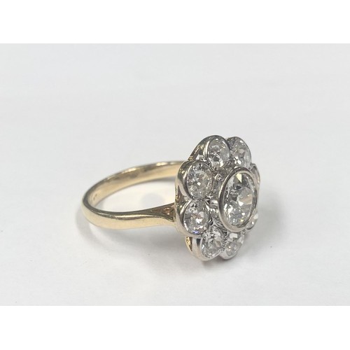 1100C - An 18ct round cluster head ring set with an early round brilliant cut diamond surrounded by 8 old cu... 