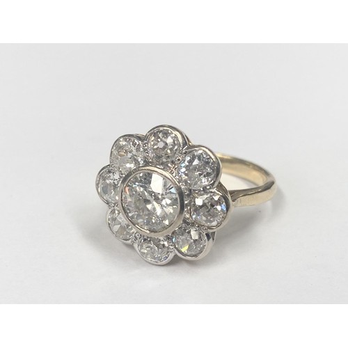 1100C - An 18ct round cluster head ring set with an early round brilliant cut diamond surrounded by 8 old cu... 