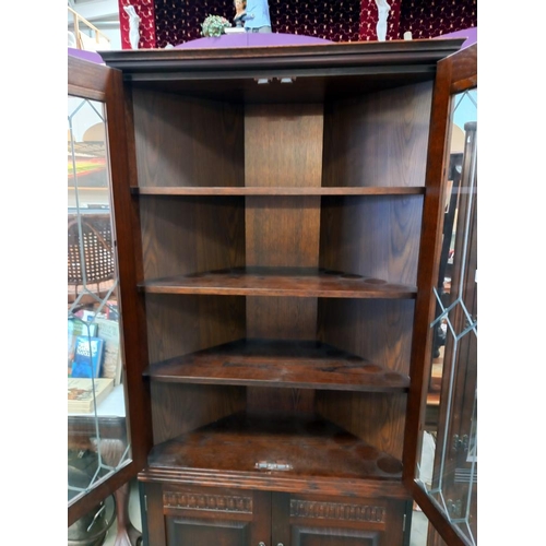 308 - A dark oak corner cupboard with leaded glass doors COLLECT ONLY