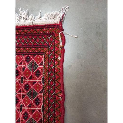 334 - An old red wool rug, 61cm x 140cm COLLECT ONLY