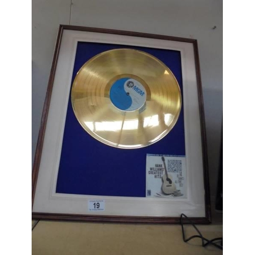 19 - A framed Hank Williams greatest hits gold disc (missing glass) COLLECT ONLY.