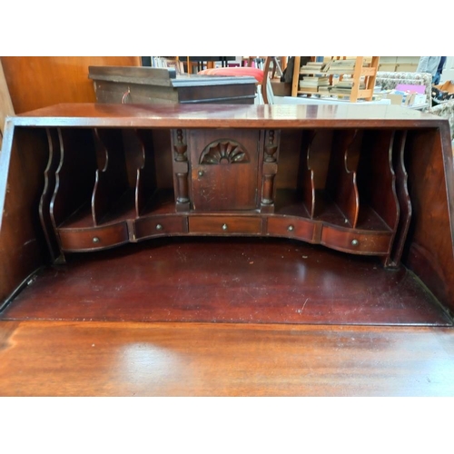 149 - A mahogany bureau with serpentine front and ball and claw legs COLLECT ONLY