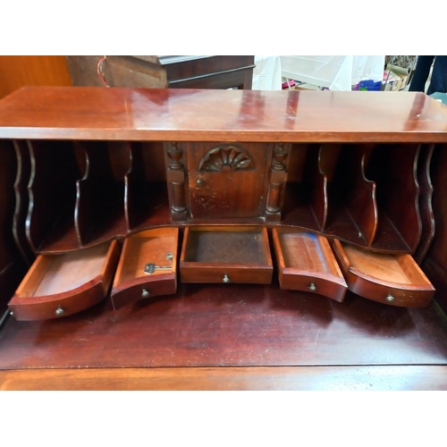 149 - A mahogany bureau with serpentine front and ball and claw legs COLLECT ONLY