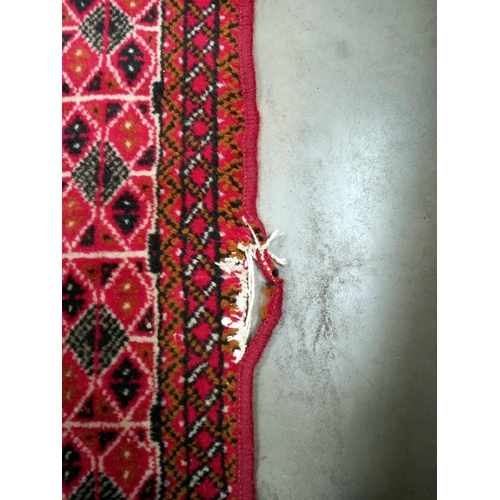 95 - An old red wool rug, 61cm x 140cm COLLECT ONLY