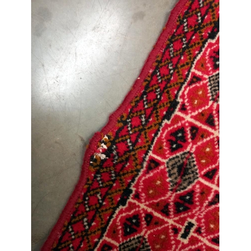 95 - An old red wool rug, 61cm x 140cm COLLECT ONLY