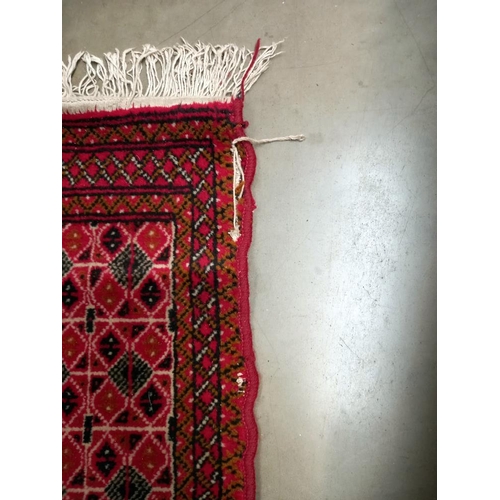 95 - An old red wool rug, 61cm x 140cm COLLECT ONLY