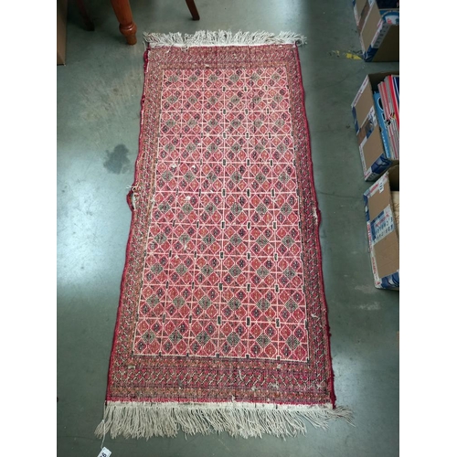 95 - An old red wool rug, 61cm x 140cm COLLECT ONLY