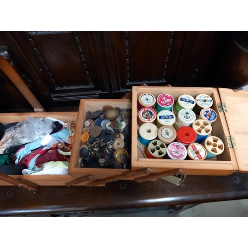 153 - A sewing box & contents including cotton reels & buttons etc. COLLECT ONLY.